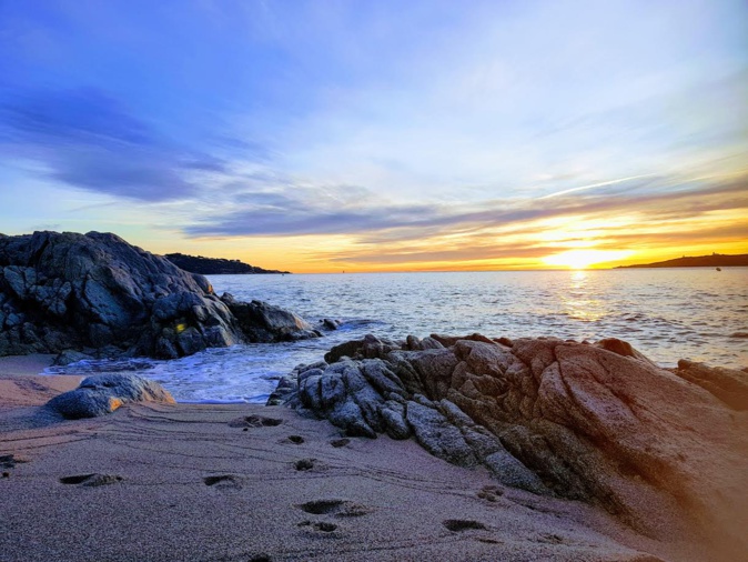 La photo du jour : quelques traces de pas sur le sable, une petite crique, des rochers, le bleu de la mer et le soleil