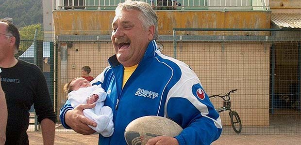 Vincent Conte avec un de ses petits-enfants dans un bras, un ballon de rugby dans l'autre. (Photo DR)