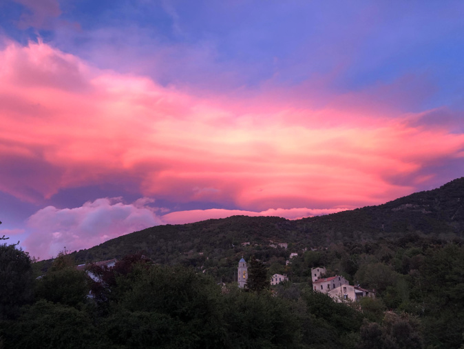 Le coucher de soleil colore les nuages au-dessus du clocher de Tavera en Corse-du-Sud (David Lavergne)