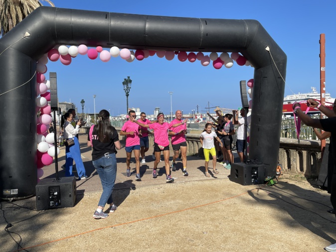 Une équipe de coureurs franchit la ligne d'arrivée du Relais rose sur la place Saint Nicolas.