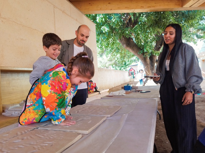 Les enfants ont pris beaucoup de plaisir à laisser leurs empreintes sur les plaques d'argile, sous le regard bienveillant des céramistes, architectes et membres de la communauté éducative.