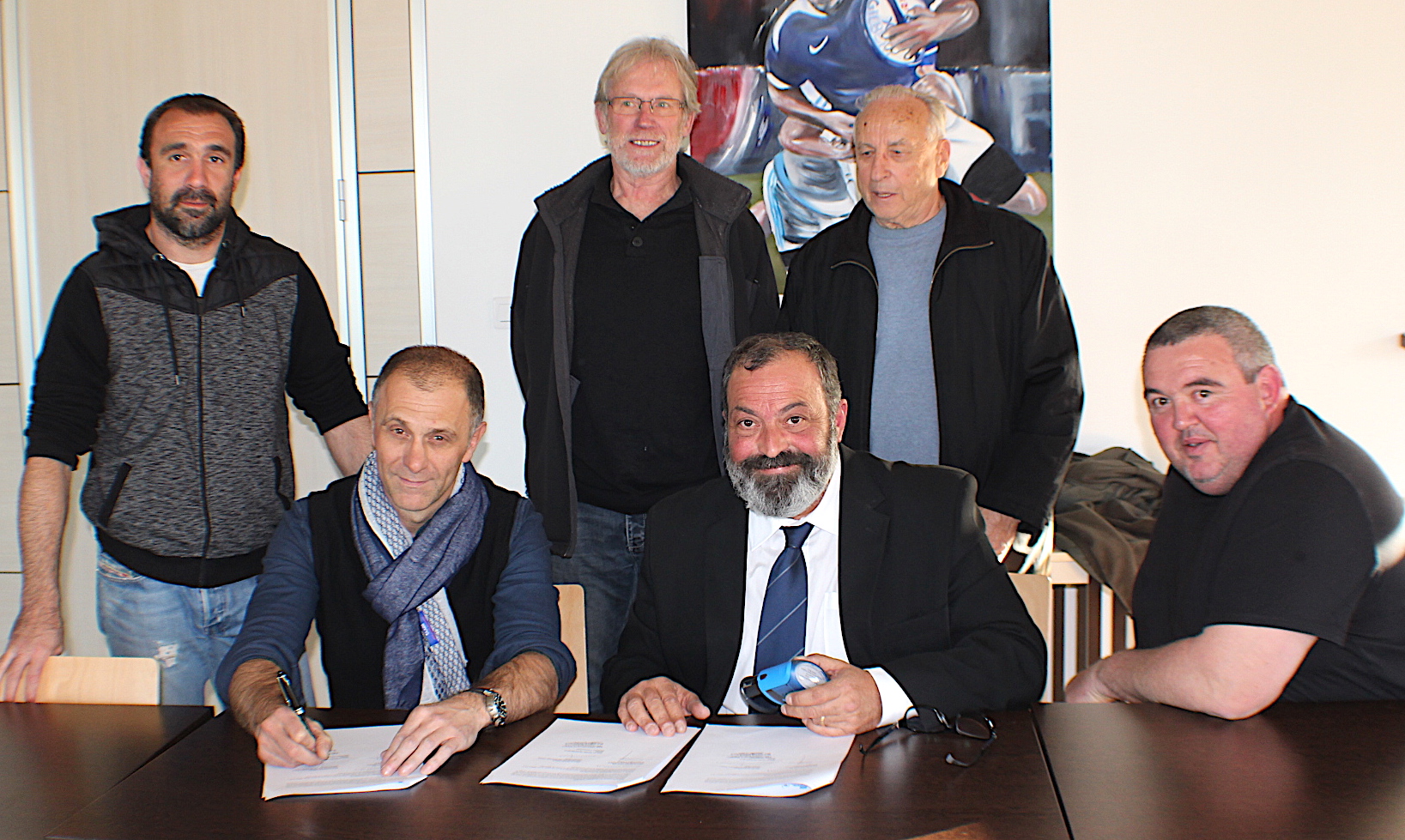 Laurent Gaya (à gauche) et Simon-Jean Savelli signent la convention qui lie le rugby corse à Gilbert en présence de Jérôme Torre, Henri Bonino, Jean Paparemborde et Henri Savary (Debout)