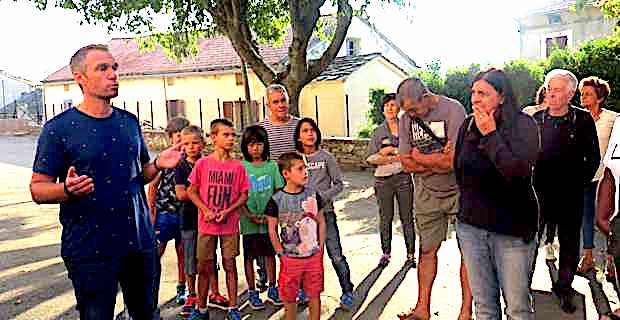 Pierre-Ange Mazzoni, délégué des parents d’élèves, entouré de parents et d'enfants dans la cour de récréation de l'école primaire de Murato.