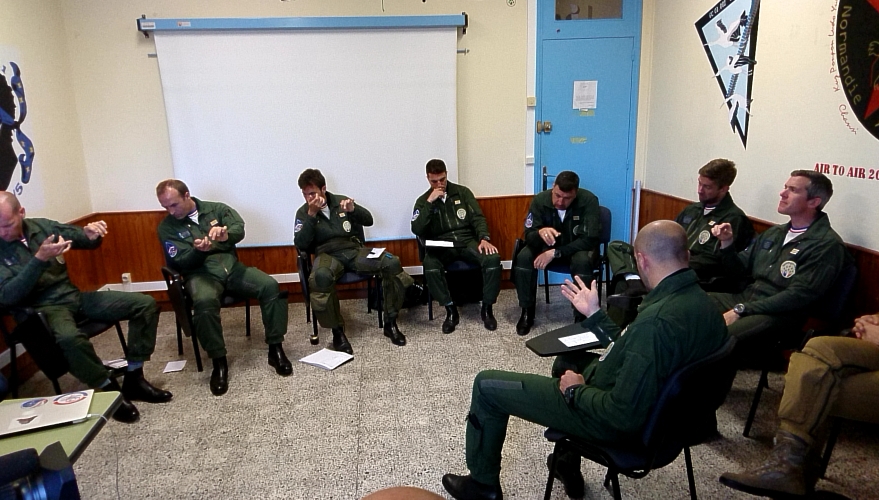 Les pilotes dans la salle de répétition pour la musique (figures en vol) d’après la météo, la pression, le vent, l’aspect de la mer.
