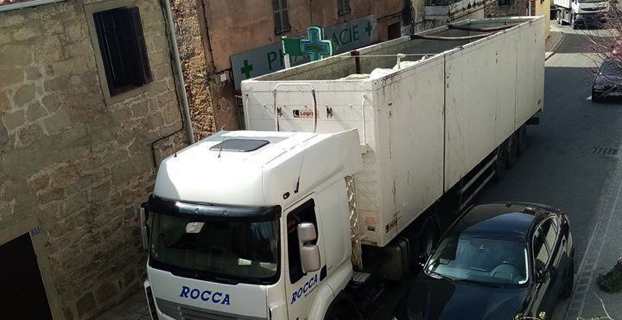 Un camion empli de balles de déchets et non bâché traverse le village d'Olmetu.