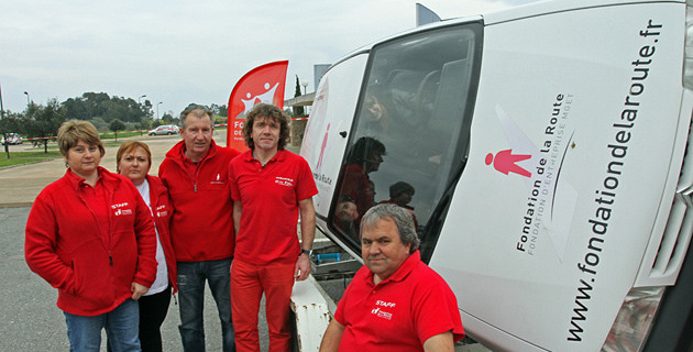 Les bénévoles de la fondation de la route et la voiture simulant les tonneaux. (Photo SG).