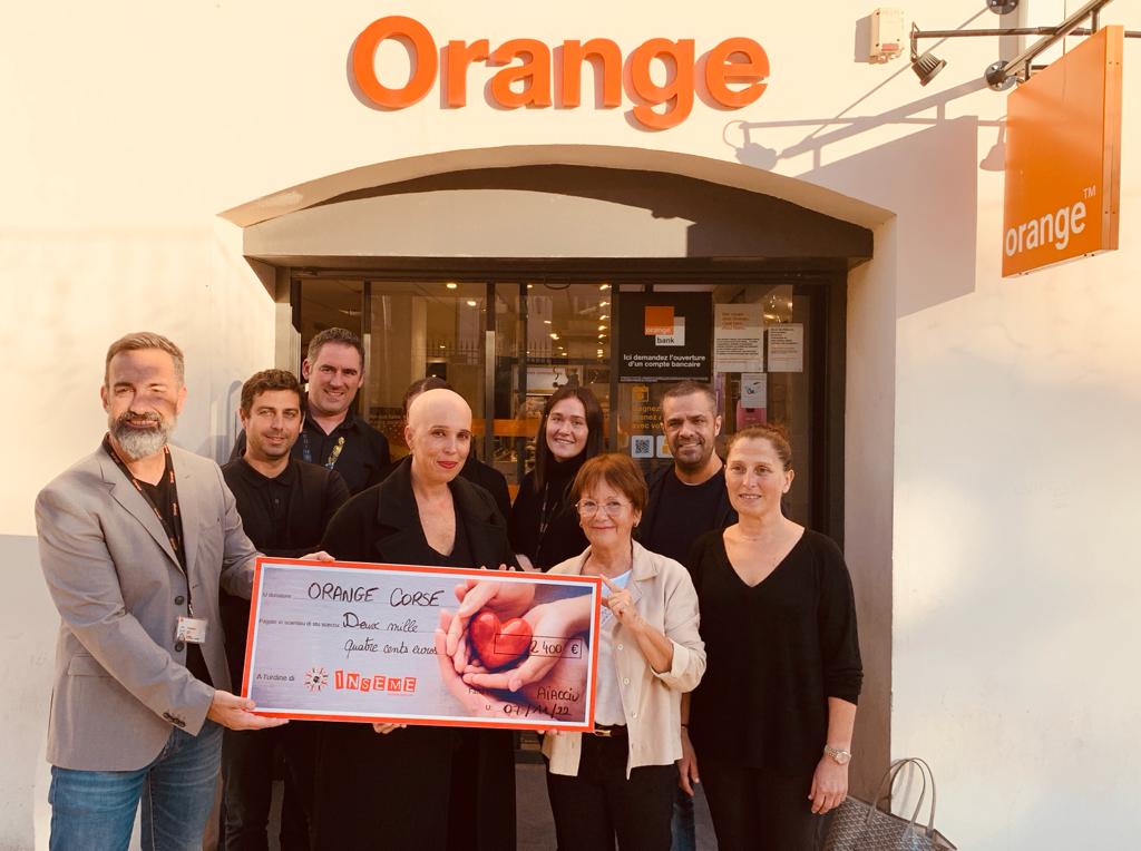 Laetitia Cucchi, présidente de l'association Inseme et  le le directeur des ventes des boutiques Orange en Corse, Michel Carli, entourés du personnel de la boutique et des bénévoles de l'asso