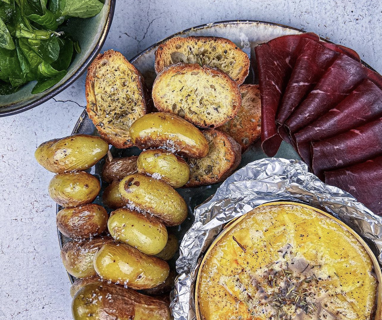 A table : Mont d'Or rôti au four à l'ail et au vin blanc, brochettes de pommes de terre et viande des grisons avec la #lapetitecuisinedemarie 