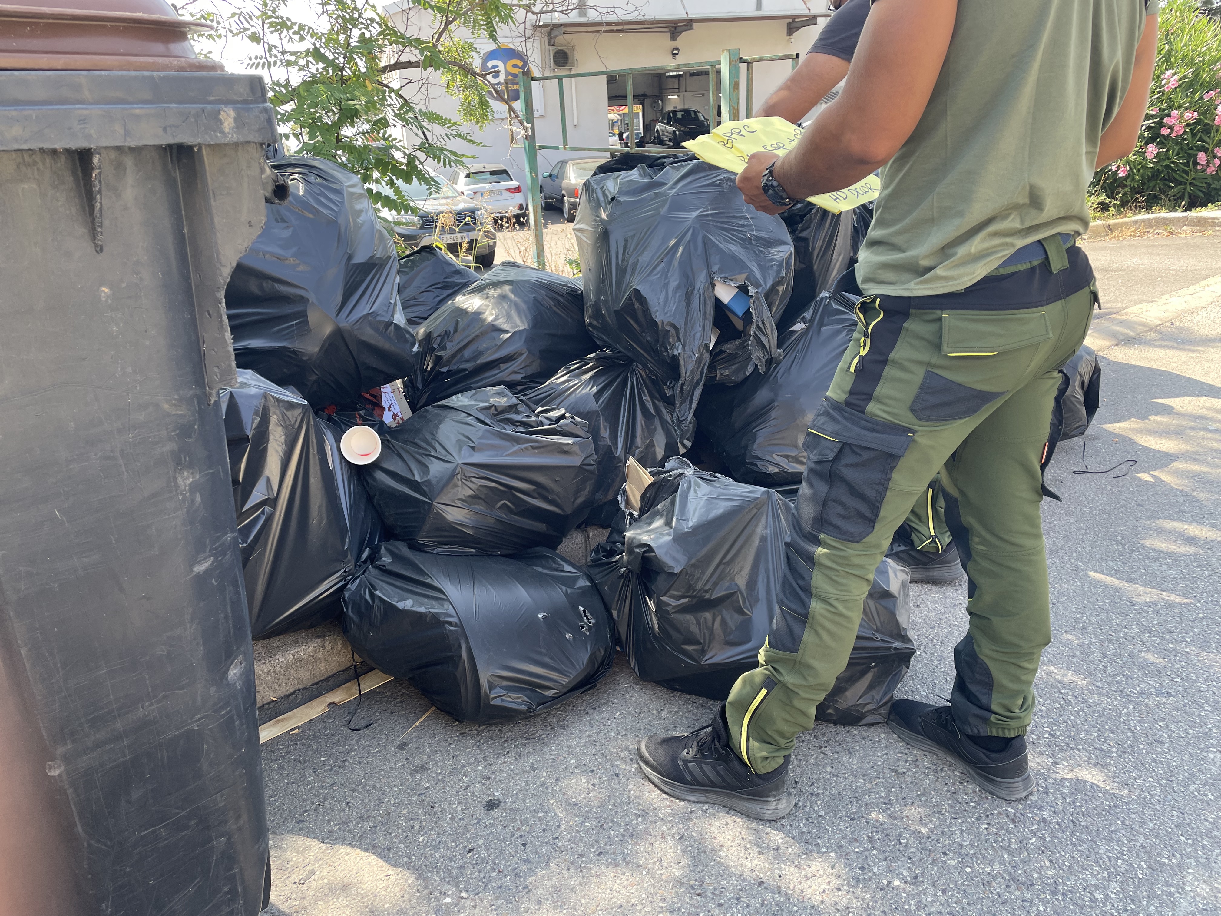 Les agents de la brigade verte examinent le contenu des poubelles à la recherche d'indices.