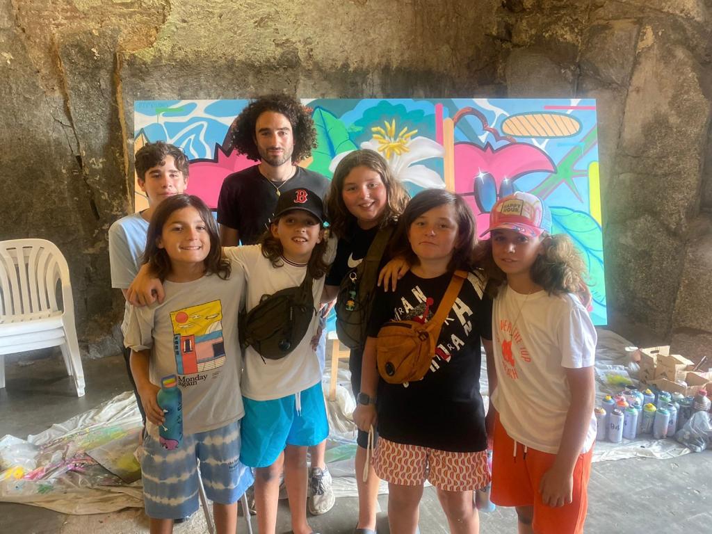 L'artiste W2CJ entouré d'enfants lors d'un précédent atelier autour du graffiti. Crédit photo: Calvi Art.