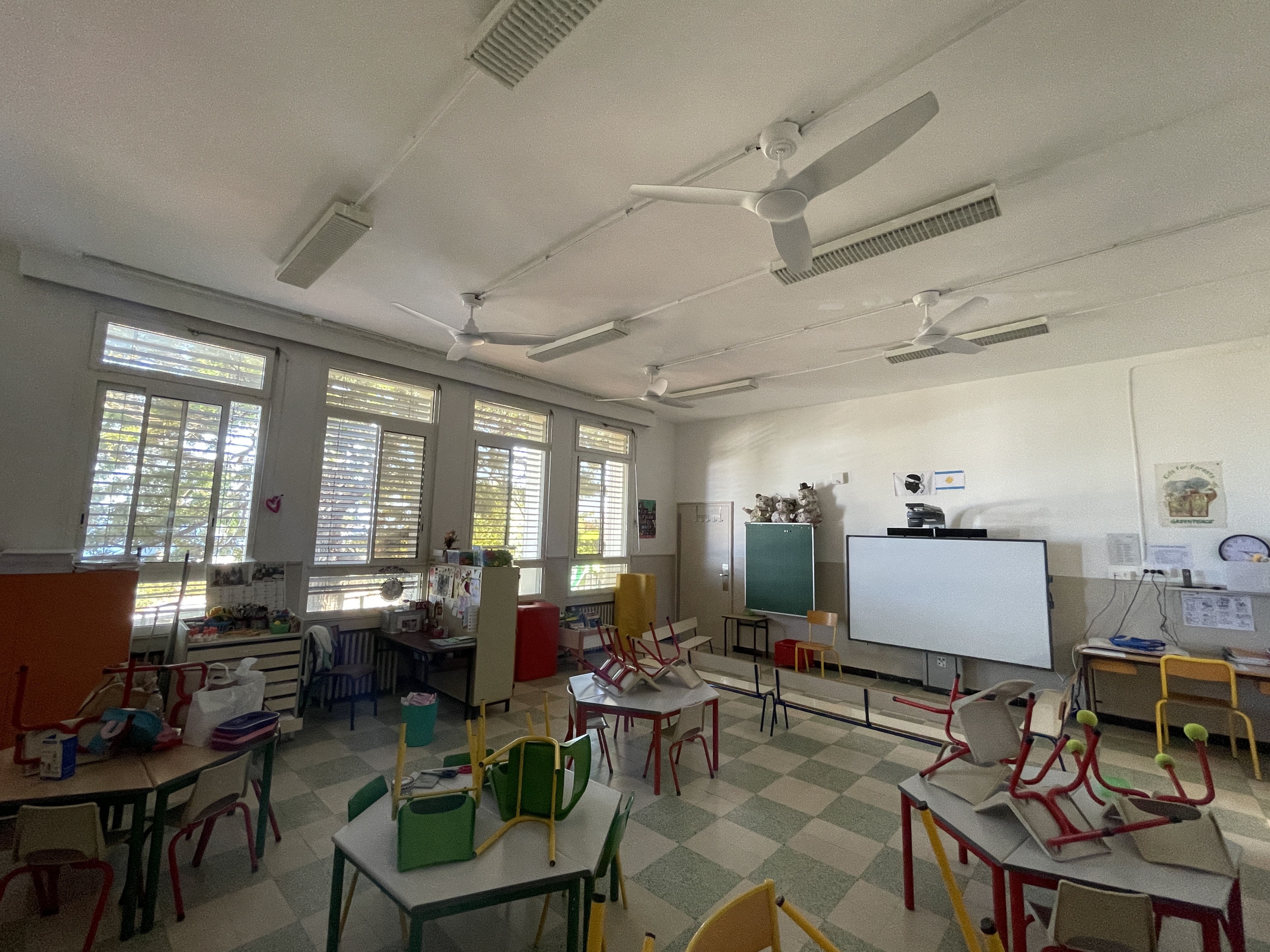 Une des salles de classe de l'école George Charpak équipée de ventilateurs au plafond et de brise-soleil devant les vitres.
