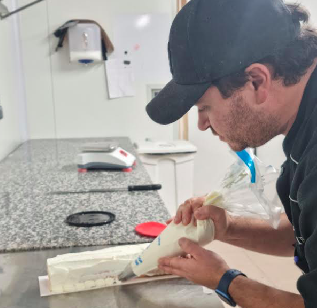 Une fois les bords coupés pour une meilleure harmonie, décorez votre bûche avec la chantilly restante. Agrémentez de fraises coupées et de décorations selon votre goût