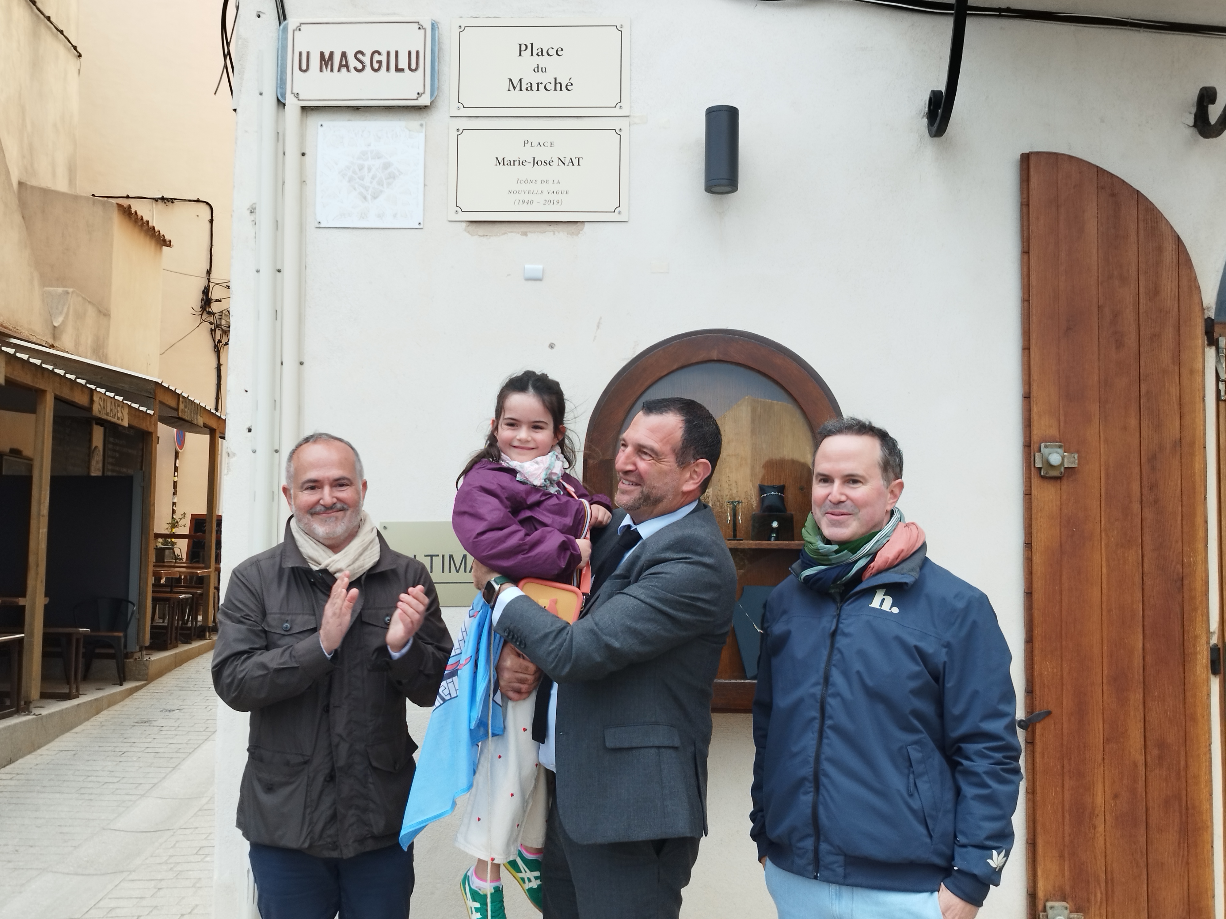La plaque "Place Marie-José Nat", dévoilée par sa famille et le maire. Jean-Charles Orsucci tient dans ses bras Rose, la petite-fille de Marie-José Nat : "Quand je regarde son visage, j'ai l'impression de voir sa mère enfant..."