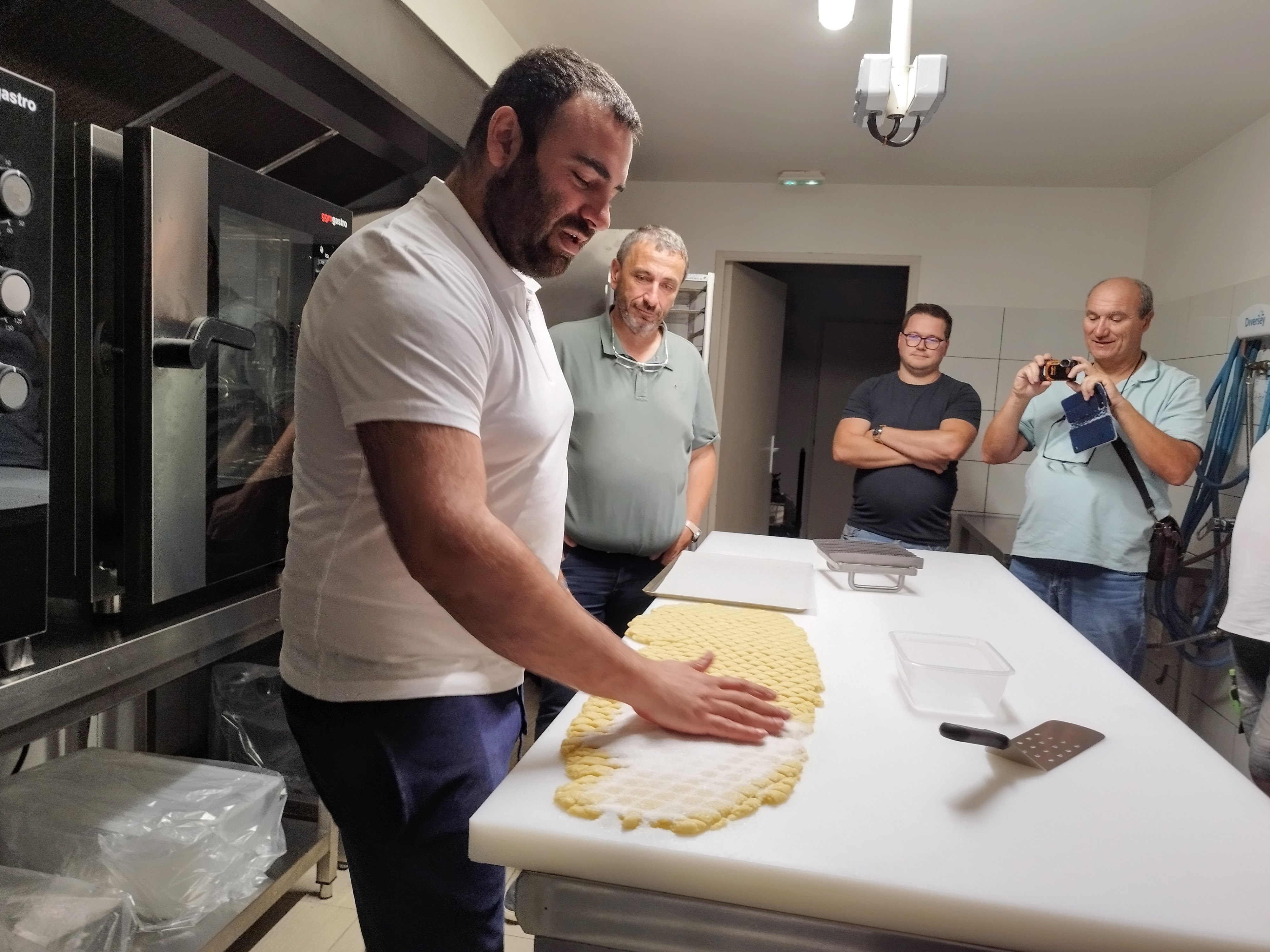 Le député Paul-André Colombani observe le savoir-faire artisanal de François-Marie Scelo dans la fabrication des canistrelli.